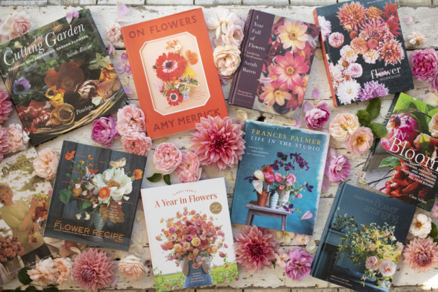 Overhead of Floret's favorite books surrounded by dahlias and roses